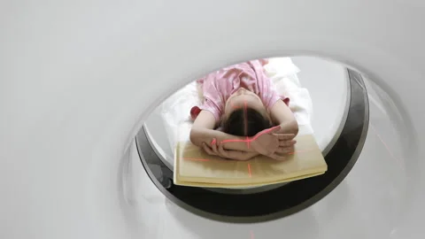 Child inside CT scanner during scan with laser positioning lines. Stockbeeldmateriaal 347777278