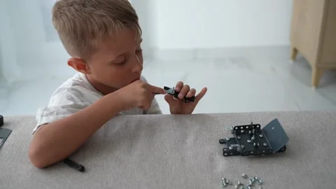 Child Installing Metal Mounting Bracket with Screwdriver at Home Stock Footage 346847342