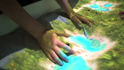 Child Interacting with Digital Augmented Reality Sandbox, Creating a Lake Stockbeeldmateriaal 334039298