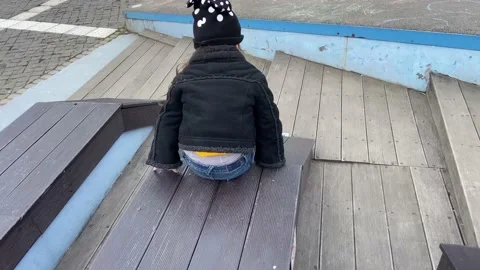 The child invented how to ride on the sloping part of the bench. Stock Footage 238556940