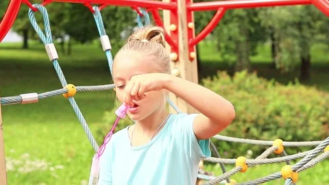 Child joyfully plays with bubbles at vibrant park playground Stock Footage 296335530