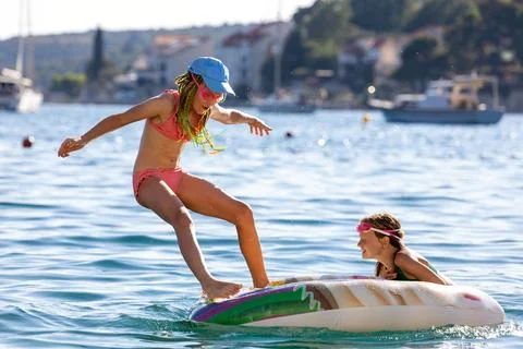Child jump inflatable float sea water sunny summer vacation playful energy Stock Photos
