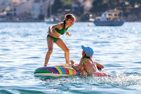 Child jump inflatable float sea water sunny summer vacation playful energy Stock Photos