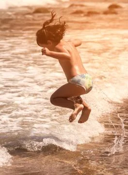Child jumping on the beach Stock Photos