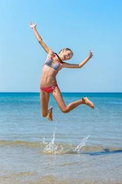 	Child jumping at the beach Stock Photos