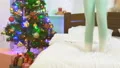 The child jumping on the bed near the christmas tree 4k or 4k+ Resolution