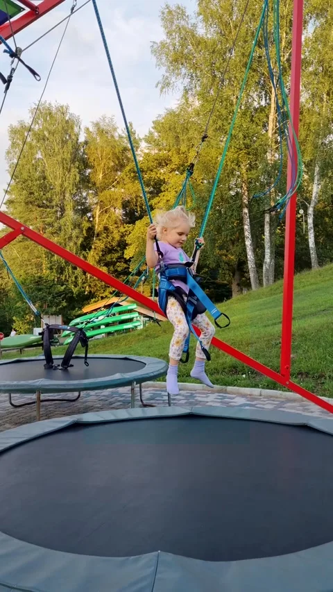 Child jumping on the bungee trampoline Stock Footage 282587820
