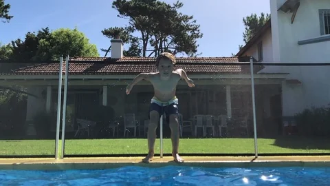 Child jumping inside swimming pool going underwater in super slow-motion Stock Footage 117257063