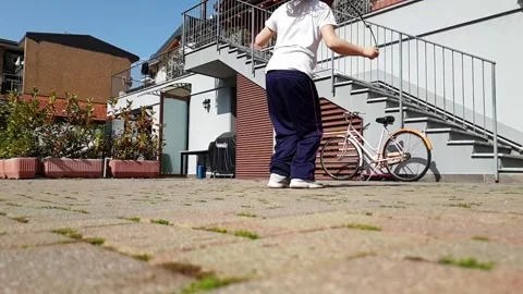 Child jumping with rope in backyard slow motion low angle Stock Footage 280790282