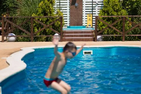 The child jumps into the pool Stock Photos