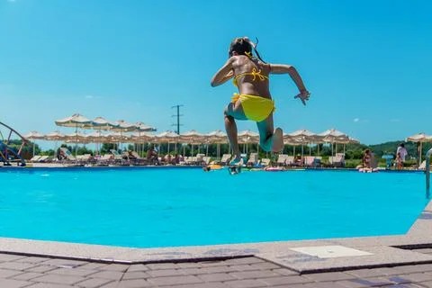 The child jumps into the pool. Selective focus. Stock Photos