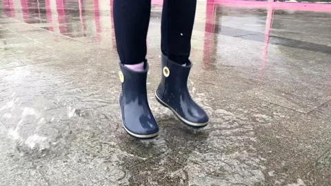 Child jumps in a puddle. Rain Stock Footage 155151339