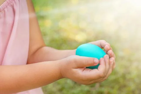 Child keeps easter egg in hands Stock Photos