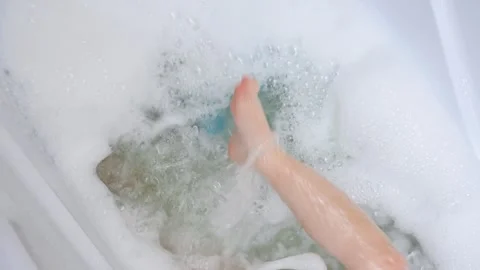 Child kicks her feet in a bubble bath Stock Footage 321933803