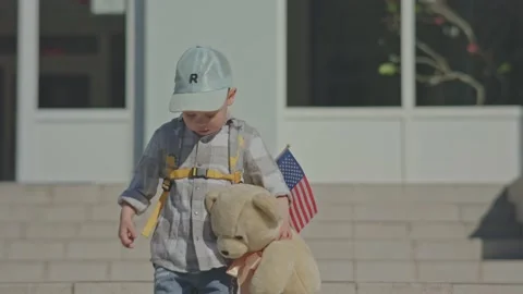 Child kid boy in cap, backpack USA flag and teddy bear walking building stairs Video stock 196870733