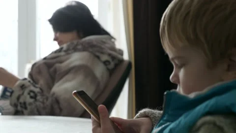 Child Kid Boy Use Watching Smartphone Internet Social Media. Mother Knit 4K Video stock 167816039