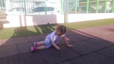 Child kid lying down and draw on the playground with chalk . childhood mortgage Stock Footage 246981450