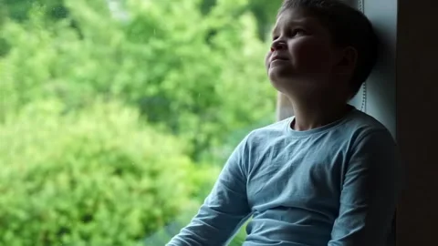 Child kid sitting on window sill looking on green tree at home in summer. bor Stock Footage 134490813