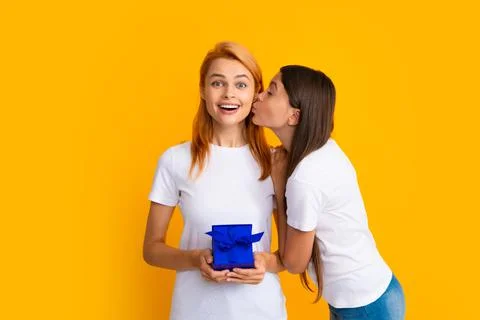 Child kissing mom. Mother and daughter with present gift. Teenager girl giving Stock Photos
