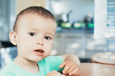 The child in the kitchen eating bread Stock Photos