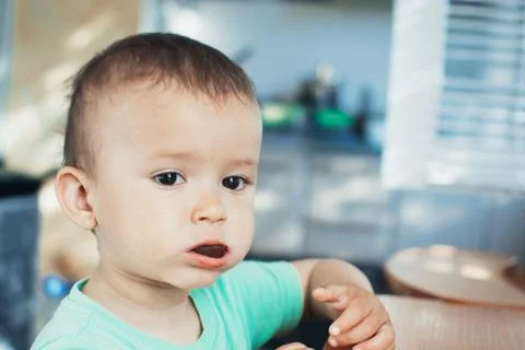 The child in the kitchen eating bread Stock Photos