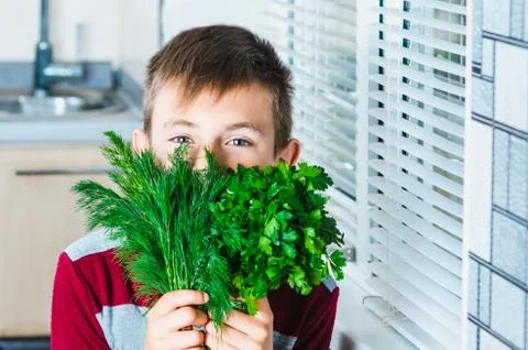 The child in the kitchen with herbs Stock Photos