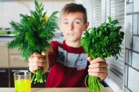 The child in the kitchen with herbs Stock Photos