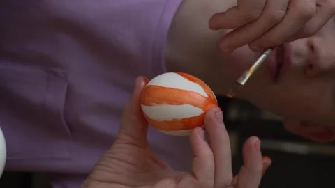 Child in the kitchen painting Easter eggs Stock Footage 263989043