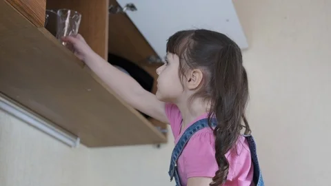 A child in the kitchen pours water. Stock Footage 116043525