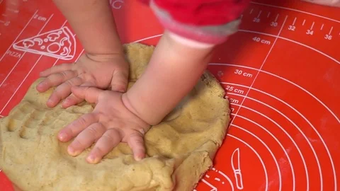 The child kneads the dough on the table Stock Footage 84828772