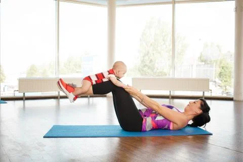 A child laughs fun while doing sports with his mother Stock Photos