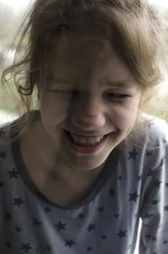 A child laughs at the window Stock Photos