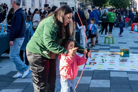 Child Learning Archery at Outdoor Event 스톡 사진