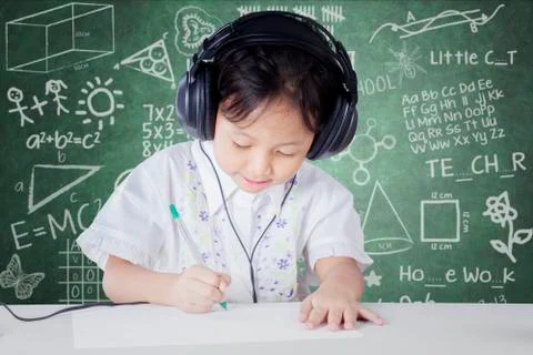 Child learning in class while wearing headphones Stock Photos