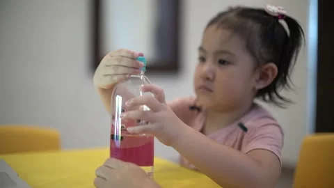Child learning to close a bottle cap for basic life skill Stock Footage 158951166