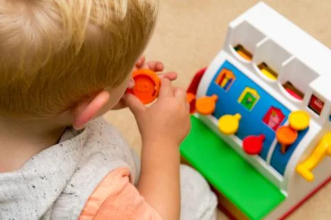 Child learning to count by playing with toy till Foto stock