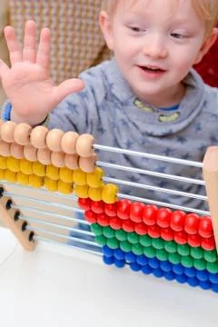 Child learning to count. Young boy using an abacus to learn maths Stock Photos