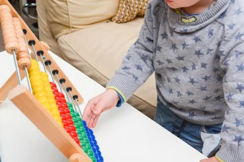 Child learning to count. Young boy using an abacus to learn maths Stock Photos