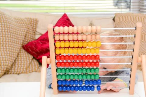 Child learning to count. Young boy using an abacus to learn maths Stock Photos