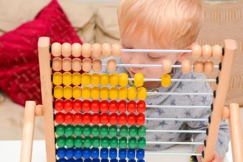 Child learning to count. Young boy using an abacus to learn maths Foto stock