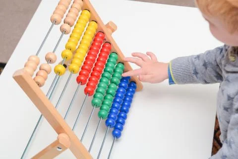 Child learning to count. Young boy using an abacus to learn maths Stock Photos