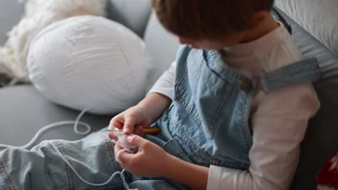 Child, learning crocheting, knitting, hand Crochet basics. Kid sitting at h.. Video stock 302347581
