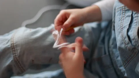 Child, learning crocheting, knitting, hand Crochet basics. Kid sitting at h.. Video stock 302347605