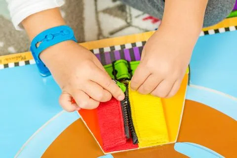 Child is learning to do up zip Stock Photos