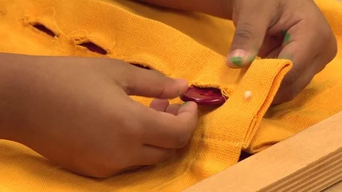 A child learning how to button in a Montessori School Class  Stock Footage 83224874