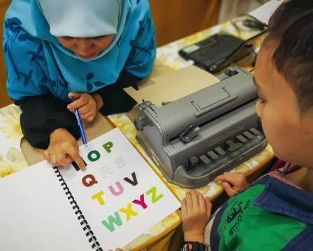 Child learning how to use the braille typewriter. Foto stock