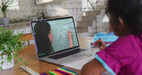 Child learning via laptop tutor writing on chalkboard copying notes while Stock Footage 330653015