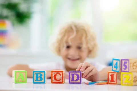 Child learning letters. Kid with wooden abc blocks Stock Photos