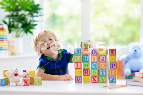 Child learning letters. Kid with wooden abc blocks Stock Photos