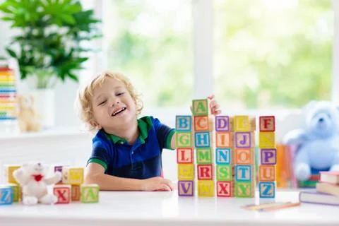 Child learning letters. Kid with wooden abc blocks Stock Photos